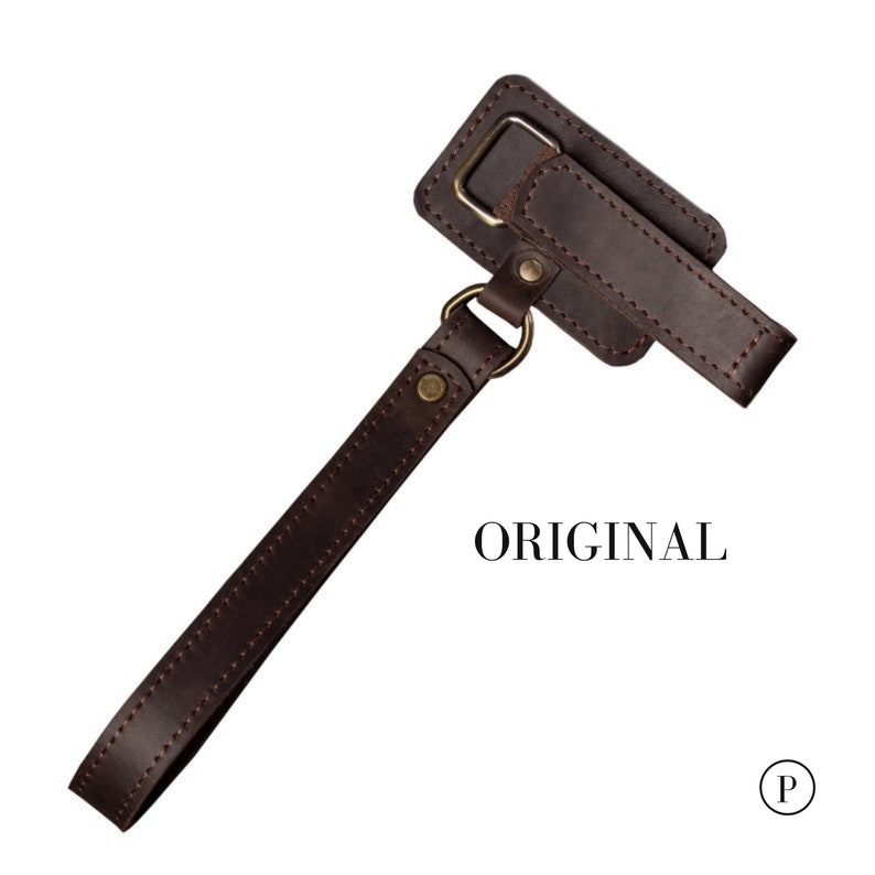 May include: A brown leather strap with a metal loop and a small brown leather pouch with a metal loop. The pouch has a flap with a stitched edge and the text "ORIGINAL" is printed below it.