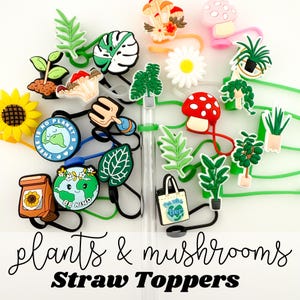 May include: A set of colorful silicone straw toppers featuring plants and mushrooms. The toppers include a variety of designs, such as a mushroom with red dots, a potted plant, a sunflower, and a leaf. The text "There is no planet B" and "Be Kind" are also included on some of the toppers.