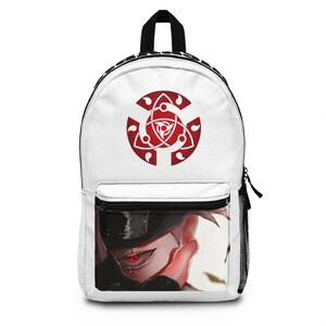 May include: White backpack featuring a red and white graphic design. The backpack has a black zipper, a front pocket, and a side mesh pocket. The design includes a red symbol and a character illustration with a red eye.