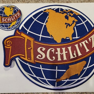 May include: A blue and white embroidered patch with a globe and a red banner that says "Schlitz".