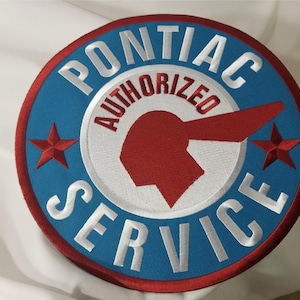 May include: A blue and red circular patch with white embroidery. The patch reads "Pontiac Authorized Service" with a red and white arrowhead logo in the center.