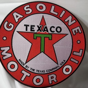 May include: Red and white circular patch with the text "GASOLINE MOTOR OIL" around the edge. A red star with a green "T" in the center and the text "TEXACO" above the "T". The text "MADE BY THE TEXAS COMPANY, U.S.A." is below the star.