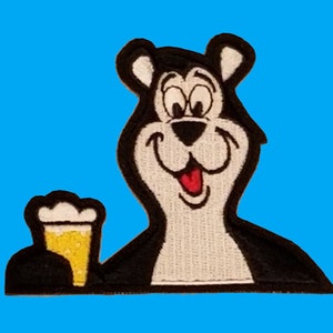 May include: A black and white cartoon bear with a big smile is holding a glass of beer. The bear is wearing a black shirt and has a white belly.