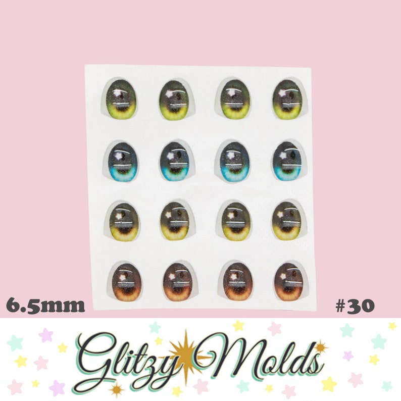 May include: A sheet of 16 oval-shaped eye decals in various colors, including green, blue, and brown, with a white highlight and a star design. The text "6.5mm" and "#30" are visible, along with the "Glitzy Molds" logo.
