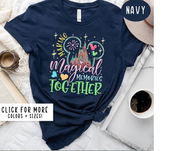 May include: Navy blue t-shirt with a graphic of Cinderella's castle and Mickey Mouse ears. The text "Making Magical Memories Together" is printed on the shirt.