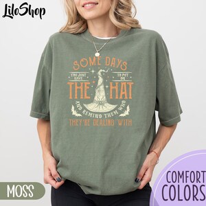 May include: Green t-shirt with a graphic of a witch's hat and the text "Some days you just have to put on the hat and remind them who they're dealing with".