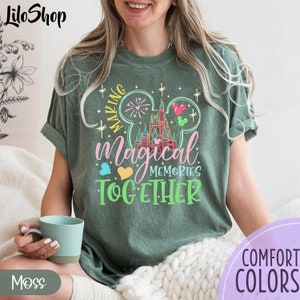 May include: A green t-shirt with a graphic of Mickey Mouse ears and the text "Making Magical Memories Together". The graphic includes a colorful image of Cinderella's Castle.