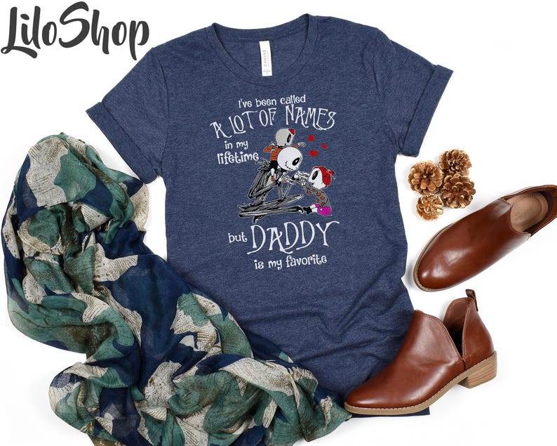 May include: A navy blue t-shirt with a graphic of three skeletons from the Nightmare Before Christmas movie. The text on the shirt reads "I've been called a lot of names in my lifetime but Daddy is my favorite."