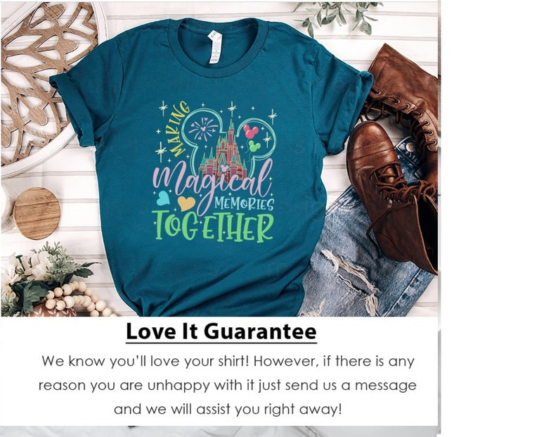 May include: Teal blue t-shirt with a graphic of the Cinderella's Castle at Walt Disney World, fireworks, Mickey Mouse ears, and the text "Making Magical Memories Together".