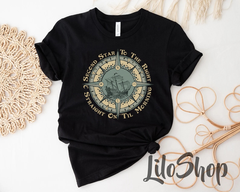 Puede incluir: Camiseta negra con un dise&ntilde;o de br&uacute;jula que presenta un barco y el texto "Second Star to the Right and Straight On Til Morning".