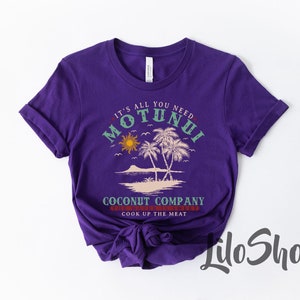 Pode incluir: Camiseta roxa de manga curta com um design gr&aacute;fico que apresenta palmeiras, um sol e o texto "It's all you need Motunui Coconut Company The water is sweet Cook up the meat".
