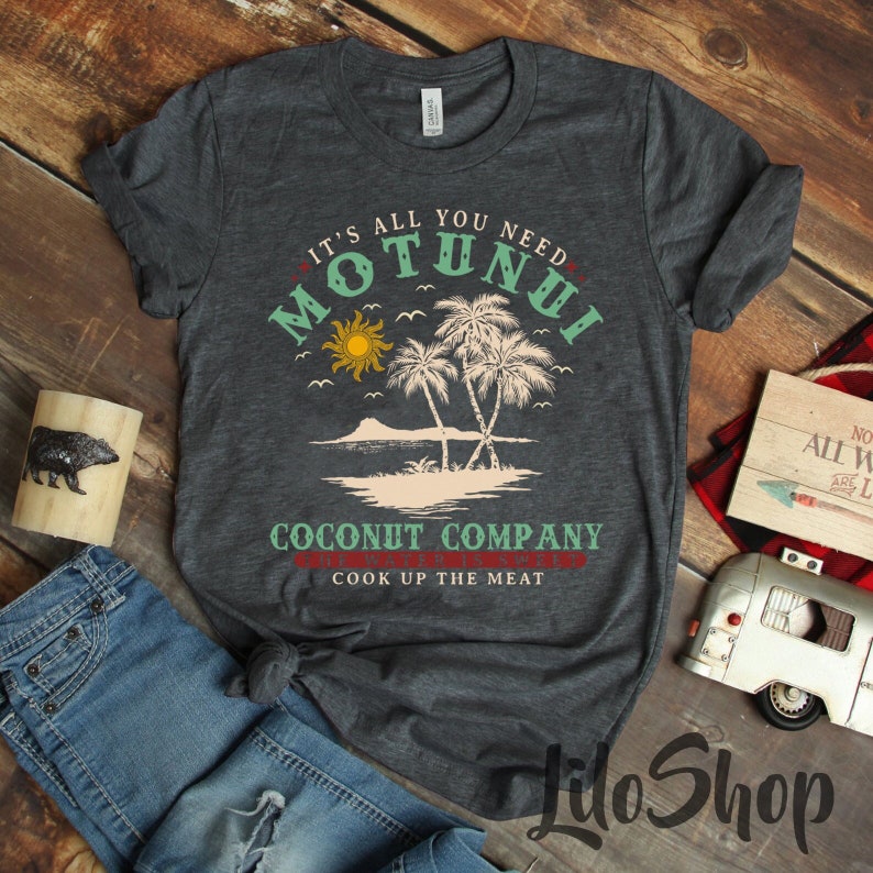 Pode incluir: Uma camiseta cinza escura com um design gr&aacute;fico que apresenta uma cena de ilha tropical com palmeiras, um sol e o texto "It's all you need Motunui Coconut Company Cook up the meat".