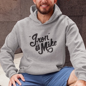 May include: A gray hooded sweatshirt with the text "Iron Mike" in black cursive lettering and a pair of boxing gloves hanging from the "I".