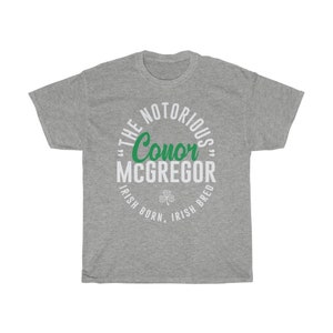 Le célèbre combattant graphique Conor McGregor porte un t-shirt unisexe Sport Grey
