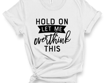 May include: White t-shirt with black text that reads "Hold on let me overthink this".