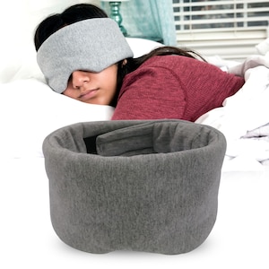 May include: Gray sleep mask with a contoured design for comfortable sleep. The mask is made of soft, breathable fabric and has a contoured shape that fits snugly around the eyes.