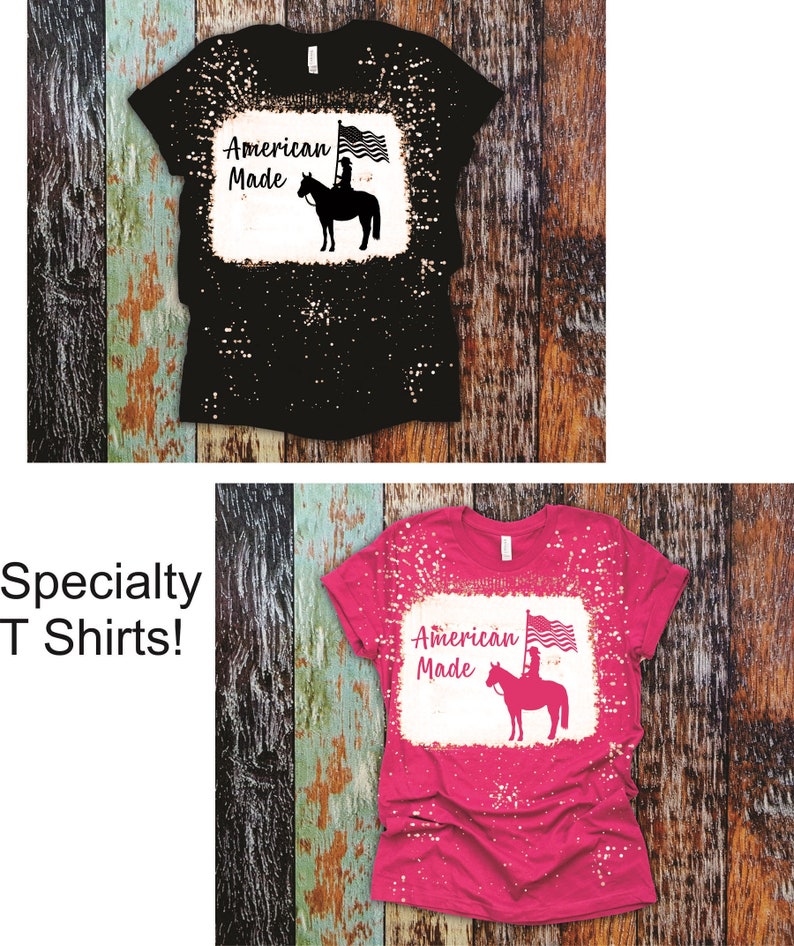 May include: Two bleached t-shirts with a distressed look. The shirts feature a silhouette of a woman riding a horse with an American flag. The text "American Made" is printed on the shirts.