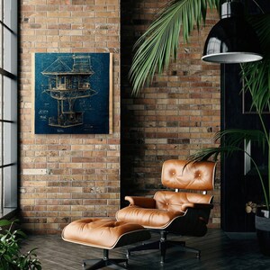 May include: A blueprint style illustration of a treehouse printed on a wood panel with a dark blue background. The illustration is framed and hanging on a brick wall. A brown leather armchair and ottoman are in the foreground.