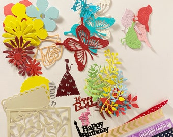 May include: Assortment of colorful paper die cuts featuring butterflies, flowers, leaves, and the words "Happy Birthday".