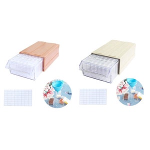 May include: Two clear plastic bead storage boxes with drawers. The boxes are beige and pink. Each box has a clear drawer with small compartments for storing beads. The boxes are on a white background.