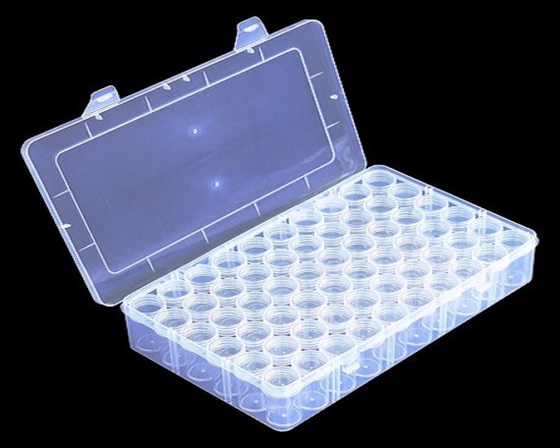 May include: A clear plastic storage box with a hinged lid. The box is filled with small, clear plastic containers, each with a lid. The containers are arranged in a grid pattern.