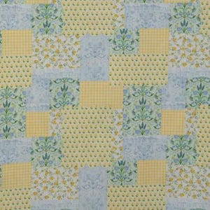 May include: A patchwork fabric design featuring squares of various patterns. The design includes yellow gingham, floral prints with yellow flowers, and light blue damask and floral patterns. The overall color scheme is soft and pastel.