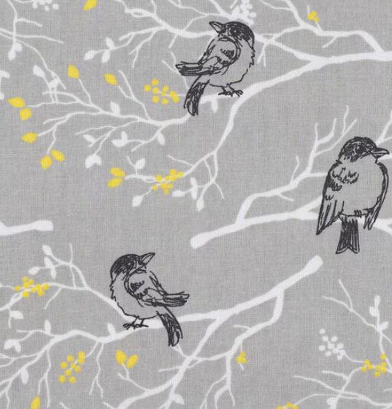 May include: A gray fabric with a white branch pattern and black birds. The birds are perched on the branches and have a simple design.
