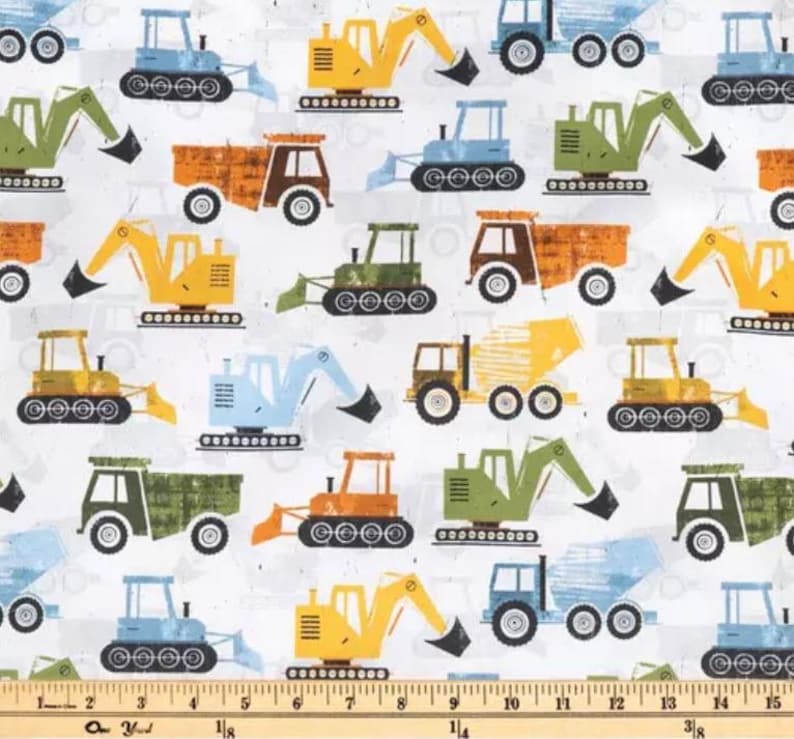 May include: A white fabric with a repeating pattern of various construction vehicles. The vehicles are in shades of yellow, blue, green, brown, and orange. The vehicles include dump trucks, excavators, bulldozers, and cement mixers.