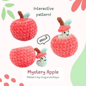 May include: A crocheted apple toy with a hidden compartment that reveals a smiling worm when opened. The apple is red and the worm is green. The text "Hello" is written on a speech bubble next to the apple. The text "Interactive pattern!" is written above the apple. The text "Mystery Apple Pattern by hugurumi toys" is written below the apple.