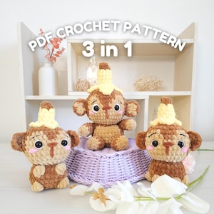 May include: Three crocheted monkey plushies with banana hats. The monkeys are brown with yellow yarn for the banana hats. The monkeys are sitting on a purple wicker basket. The image includes the text "PDF CROCHET PATTERN 3 in 1".