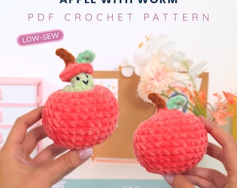 May include: Two handmade crochet apples, one with a worm peeking out. The apples are red with brown stems and green leaves. The text on the image reads "APPLE WITH WORM PDF CROCHET PATTERN" and "PATTERN BY HUGURUMITOYS".