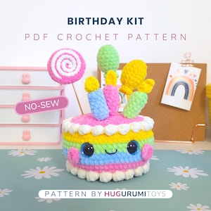 Op de afbeelding: Een kleurrijke, gehaakte verjaardagstaart met een lachend gezicht, versierd met kaarsen, een lolly en ballonnen. De taart heeft lagen roze, geel, blauw en groen. De afbeelding bevat de tekst "Birthday Kit" en "PDF Crochet Pattern".