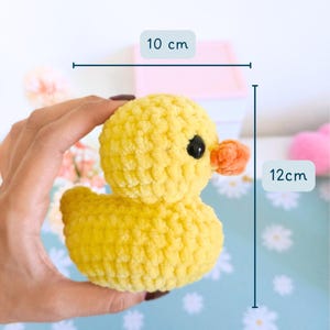 Puede incluir: Un pato amarillo hecho a mano con ganchillo y una textura esponjosa. El pato tiene un peque&ntilde;o pico naranja y ojos negros. Mide aproximadamente 10 cm de ancho y 12 cm de alto. El pato es un juguete lindo y tierno.