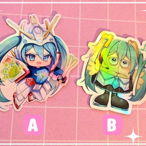 May include: Two anime-style stickers on a pink background. One features a blue-haired character in a robotic suit, holding a shield and sword. The other shows a green-haired character with a microphone and a leek. The stickers are labeled "A" and "B".