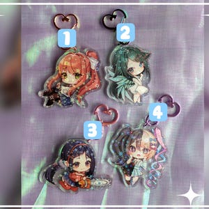 May include: Four anime-style acrylic keychains with heart-shaped clasps. Each keychain features a different character with unique hair colors and outfits. The characters are numbered 1 through 4, and are set against a purple background with star accents.