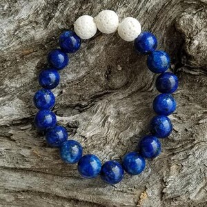 May include: A blue and white beaded bracelet with white lava beads and blue lapis lazuli beads.