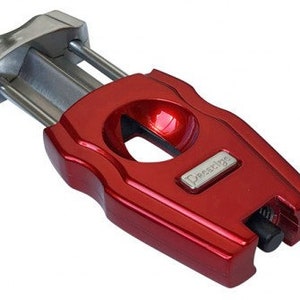 May include: A red cigar cutter with a silver blade and a "Prestige" logo. The cutter has a built-in punch and a removable blade.