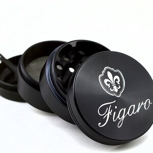 May include: Black metal grinder with a fleur-de-lis design and the word "Figaro" engraved on the side.