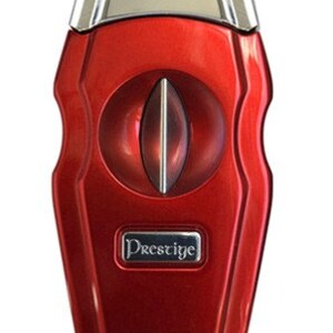 May include: Red cigar cutter with a silver top and a silver Prestige logo. The cutter has a round opening for cutting cigars.