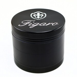 May include: Black metal grinder with four sections. The top section features a silver fleur-de-lis logo and the word "Figaro" in a cursive font.