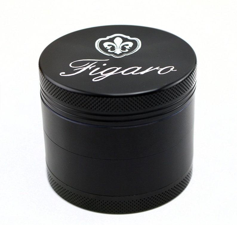 May include: Black metal grinder with four sections. The top section features a silver fleur-de-lis logo and the word "Figaro" in a cursive font.