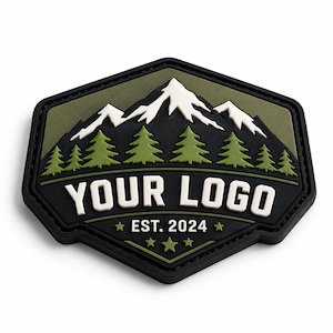 May include: A hexagonal rubber patch featuring a mountain range with white snow-capped peaks above a forest of green pine trees. The black background displays the white text "YOUR LOGO" and "EST. 2024" with small star accents in a dark olive green border.