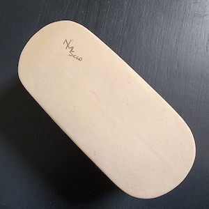 May include: A light beige oval-shaped wooden board with a handwritten signature that says "M. Secco".