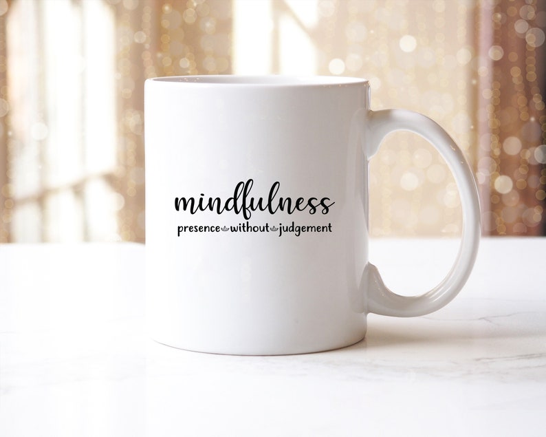 以下が含まれることがあります： 「mindfulness presence without judgement」という黒い文字が書かれた白いセラミックマグカップです。