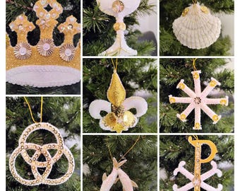 May include: A collection of handmade Christmas ornaments, including a gold crown, chalice, seashell, fleur-de-lis, snowflake, and other religious symbols. Each ornament is embellished with sequins and beads, and hangs from a gold string.