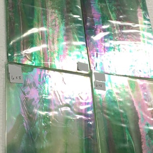 May include: Four iridescent green glass tiles with a label on each tile. The labels read "6 x 8" and "6 x 9".