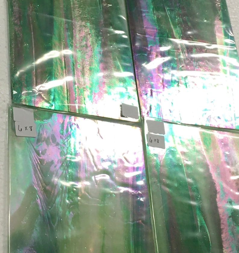 May include: Four iridescent green glass tiles with a label on each tile. The labels read "6 x 8" and "6 x 9".