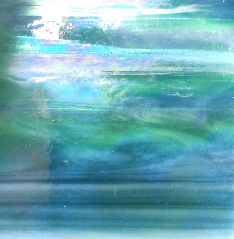 以下が含まれることがあります： 青、緑、白の色合いの抽象的な虹色の背景。色は混ざり合って、柔らかく、幻想的な効果を生み出しています。
