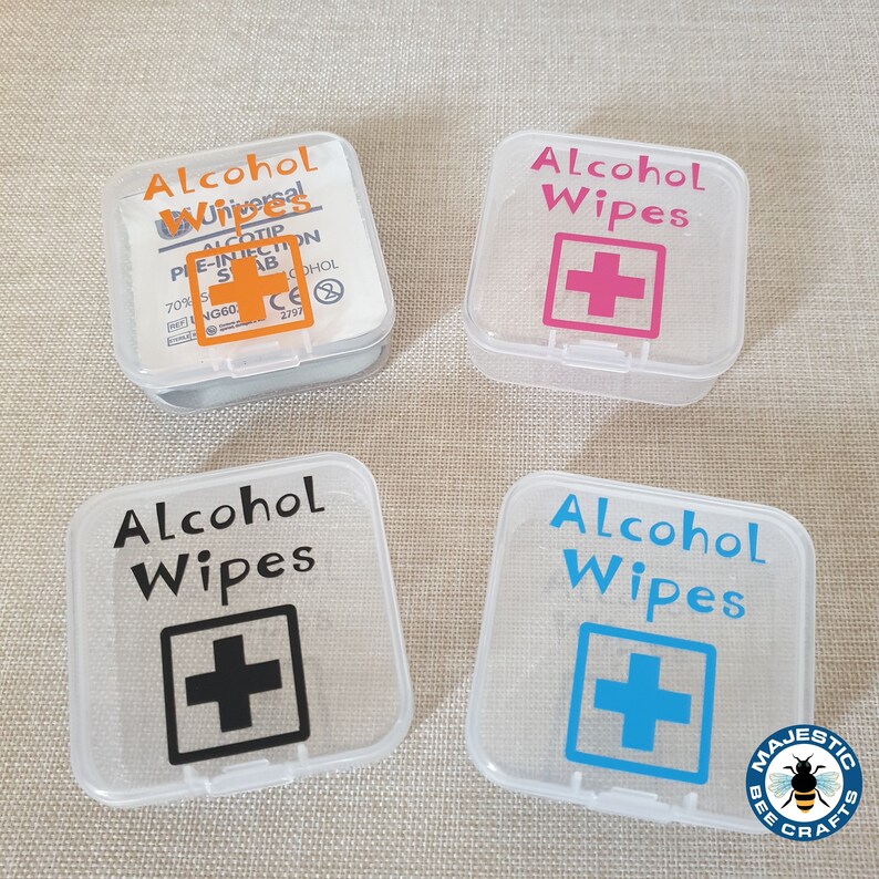 K&ouml;nnte beinhalten: Vier transparente Plastikbeh&auml;lter mit schwarzen, rosa, blauen und orangen Etiketten, auf denen "Alcohol Wipes" mit einem Pluszeichen steht. Die Beh&auml;lter befinden sich auf einer beigefarbenen Oberfl&auml;che.