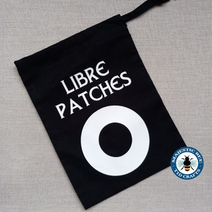 May include: Black fabric drawstring bag with white text that reads "Libre Patches" and a white circle with a black centre. The bag has a white logo with a bee and the text "Majestic Bee Tid Crafts".